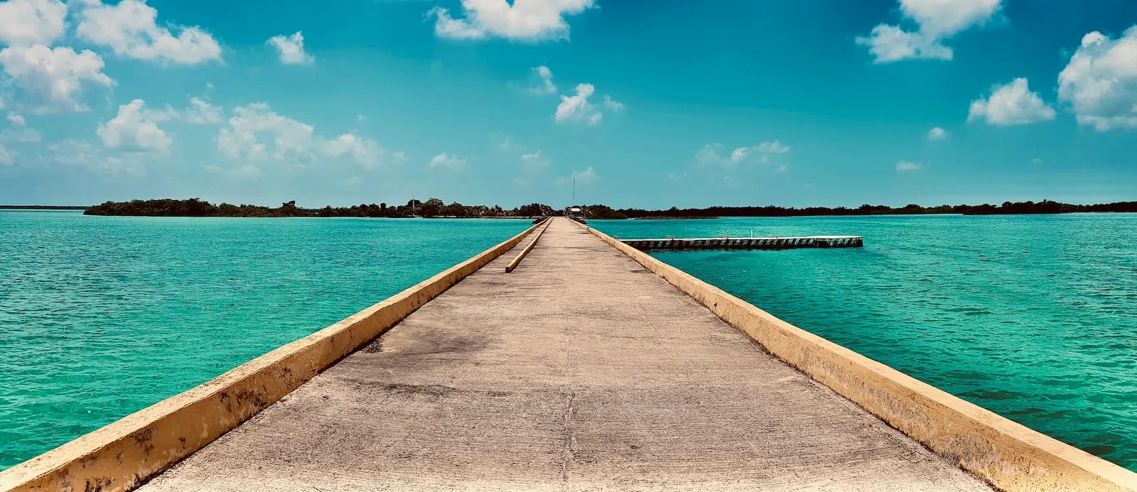 brown wooden dock on sea under blue sky during daytime