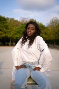 Dating a Haitian Woman - The pros and cons woman in white dress shirt and blue denim jeans sitting on road during daytime